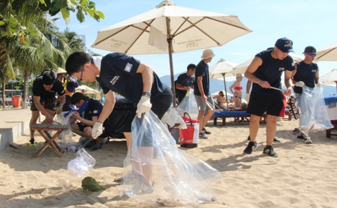 Các thủy thủ Nhật Bản thu gom rác trên bãi biển.