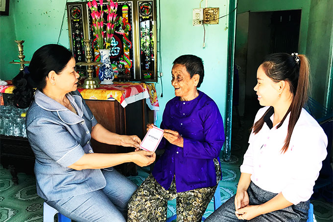 Cán bộ Hội Phụ nữ xã trao sổ tiết kiệm cho bà Trần Thị Phận.
