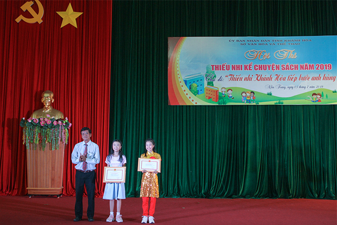 Đại diện Ban tổ chức trao giải nhất lứa tuổi nhi đồng và lứa tuổi thiếu niên cho hai thí sinh xuất sắc.  