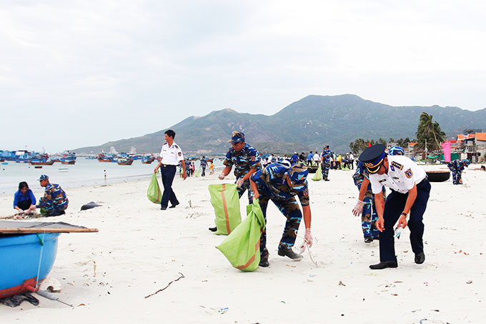 Các cán bộ, chiến sĩ Hải đoàn Cảnh sát biển 32 thu gom rác trên bãi biển Ninh Thủy.