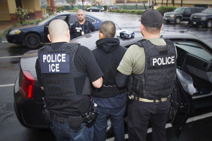 Nhân viên Cơ quan Di trú và Hải quan Mỹ (ICE) phối hợp cùng cảnh sát bắt giữ người nước ngoài không có giấy tờ trong một chiến dịch vào tháng 2/2017 - Ảnh: AFP