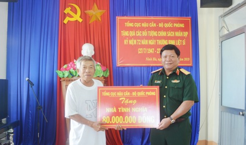 Trung tướng Lê Văn Hoàng trao tượng trưng số tiền hỗ trợ xây nhà tình nghĩa cho ông Nguyễn Lượm.
