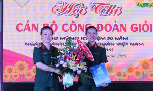 Đại tá Bùi Thị Lan Phương (bên trái) tặng hoa cho công đoàn nhà trường.