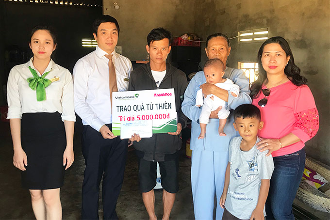 Representatives of Khanh Hoa Newspaper and Vietcombank Nha Trang offering money to the family of the two children.