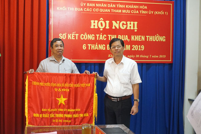 Ông Nguyễn Tấn Tuân trao Cờ thi đua cho lãnh đạo Ban Tổ chức Tỉnh ủy Khánh Hòa.