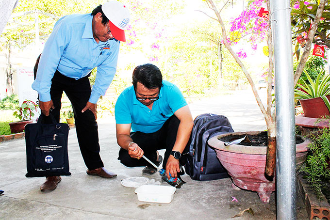 Cán bộ Viện Pasteur Nha Trang lấy mẫu nước có chứa lăng quăng  ở một trường tiểu học trên địa bàn huyện Diên Khánh. 