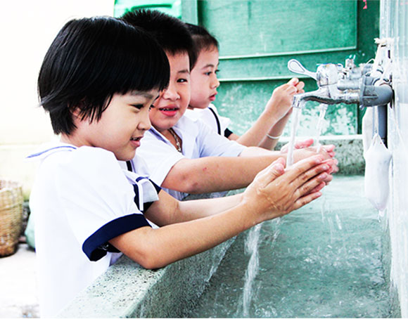 Học sinh một trường tiểu học tại TP. Nha Trang vệ sinh tay sau giờ ra chơi.  