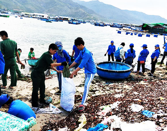 Các đoàn viên, thanh niên thu gom rác trên bãi biển.
