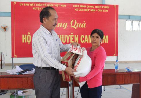Đại diện Ủy ban Mặt trận Tổ quốc huyện Cam Lâm trao quà cho hộ nghèo.