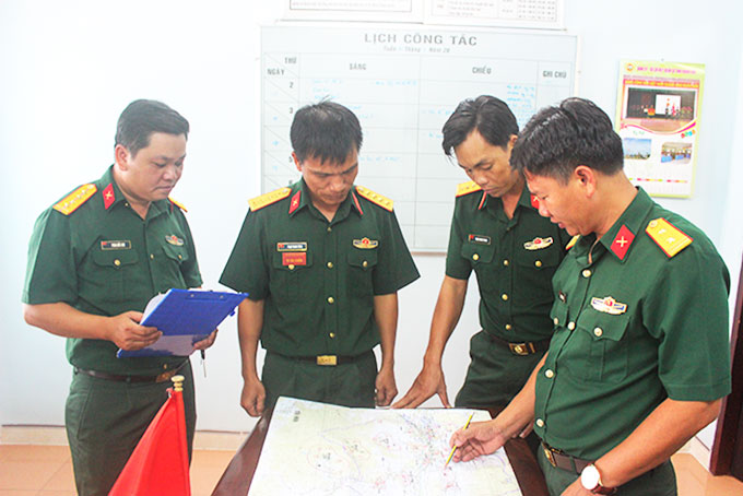 Trung tá Đặng Văn Khôi (bìa phải) thảo luận kế hoạch tập luyện cùng cán bộ phòng, ban  của Ban Chỉ huy Quân sự huyện Diên Khánh.