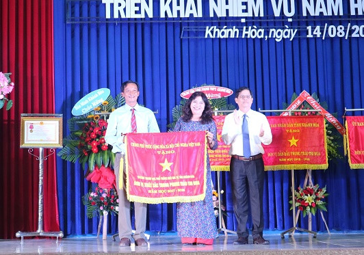 Ông Nguyễn Tấn Tuân trao cờ thi đua của Chính phủ cho Trường THPT Ngô Gia Tự.