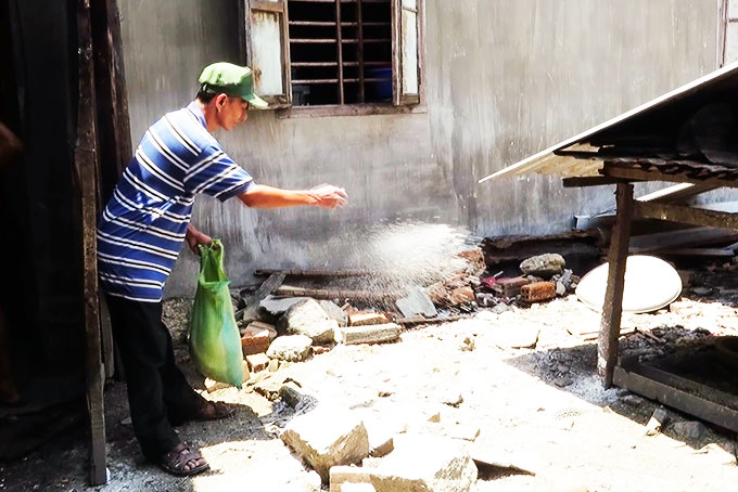 Người dân xã Diên Điền (Diên Khánh) rắc vôi bột khử trùng môi trường chăn nuôi.