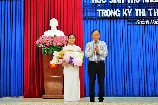 Ông Nguyễn Đắc Tài trao bằng khen của UBND tỉnh cho HS thủ khoa tốt nghiệp THPT năm 2019. 