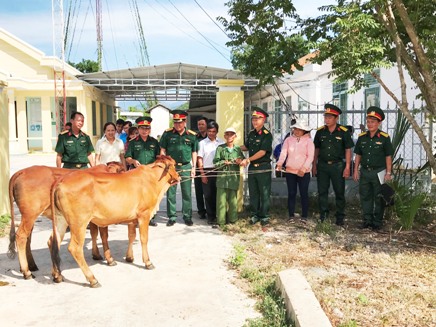 Đoàn công tác tặng bò giống cho các hộ nghèo.