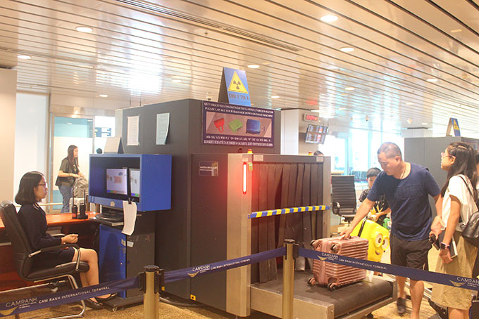 Cán bộ hải quan thực hiện soi chiếu hành lý của hành khách tại Cảng hàng không quốc tế Cam Ranh. 