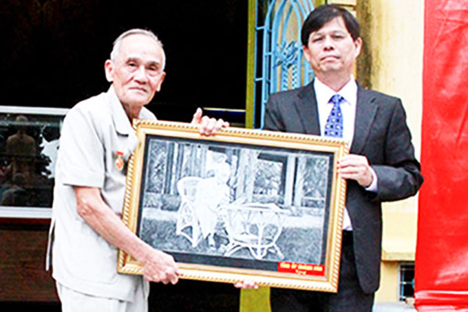 Ông Nguyễn Tấn Tuân trao tặng bức ảnh Bác Hồ cho ông Bùi Xuân Phước.