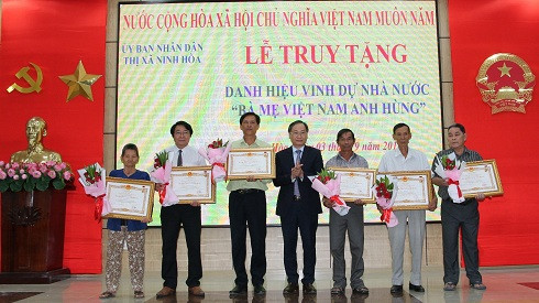 Thừa ủy nhiệm của Chủ tịch nước, ông Nguyễn Đắc Tài (đứng giữa) trao danh hiệu vinh dự Nhà nước Bà mẹ Việt Nam Anh hùng cho thân nhân các bà mẹ.
