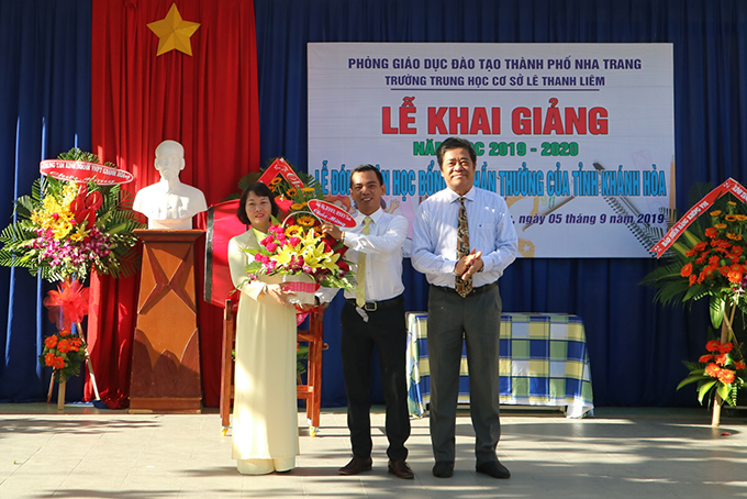 Ông Lê Thanh Quang trao lẵng hoa chúc mừng của Tỉnh uỷ, HĐND, UBND tỉnh Khánh Hòa cho nhà trường. 