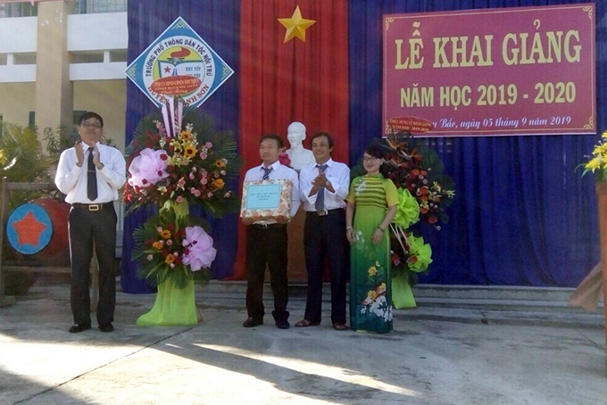 Ông Trần Mạnh Dũng (bìa trái) tặng hoa và quà cho Trường Trung học phổ thông Dân tộc nội trú Khánh Sơn.