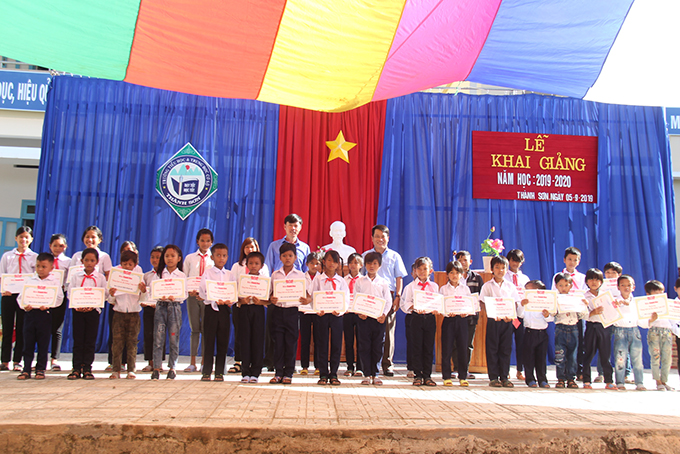 Lãnh đạo Báo Khánh Hòa và lãnh đạo Doanh nghiệp Tư nhân Phương Đài trao học bổng cho học sinh.