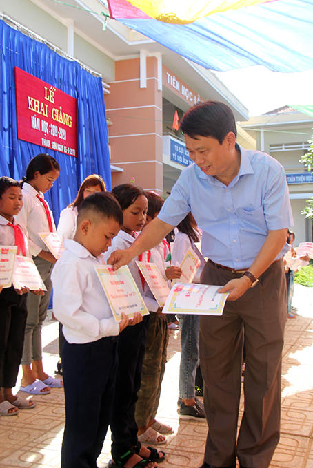 Ông Trần Duy Hưng– Tổng Biên tập Báo Khánh Hòa trao học bổng cho các em học sinh.