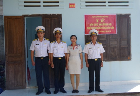 Gia đình Đại úy Mai Văn Luân (thứ hai từ trái qua) chụp hình lưu niệm với chỉ huy đơn vị tại lễ bàn giao nhà.