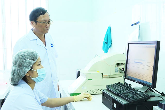 Tiến sĩ Hùng và kỹ thuật viên kiểm tra chương trình chạy thử trên máy.