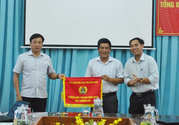 Đại diện công đoàn Trường Cao đẳng Kỹ thuật Công nghệ Nha Trang (giữa) nhận cờ đơn vị trưởng khối. 