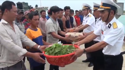 Các cán bộ, chiến sĩ trên đảo hỗ trợ lương thực cho các ngư dân gặp nạn.