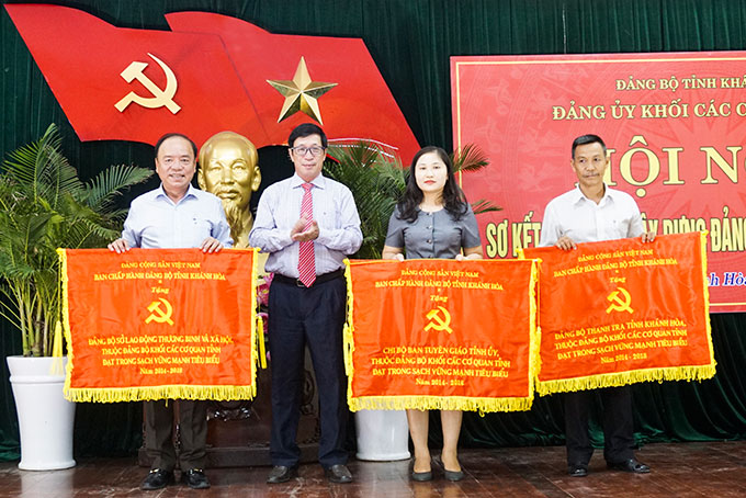 Đồng chí Lương Kiên Định trao cờ cho các tổ chức cơ sở đảng thuộc Đảng ủy Khối  đạt trong sạch, vững mạnh tiêu biểu 5 năm liền (2014 - 2018).