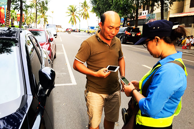 Nhân viên Công ty Cổ phần Môi trường đô thị Nha Trang thu phí đỗ xe.