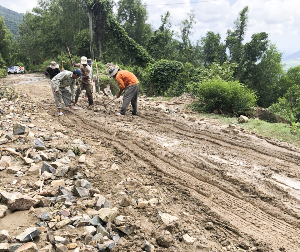 Công nhân hốt dọn đất đá bị tràn ra đường.