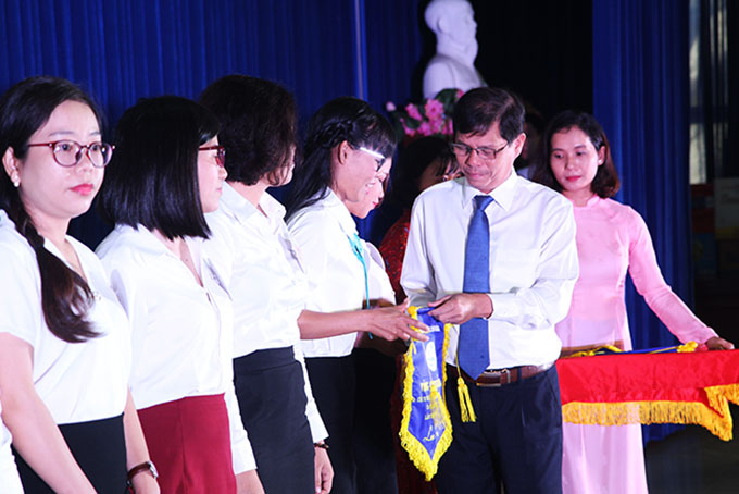 Ông Nguyễn Tấn Tuân trao cờ lưu niệm cho các đội thi.