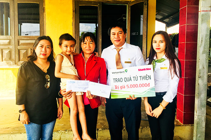 Đại diện Báo Khánh Hòa và Vietcombank Nha Trang trao tiền ủng hộ cho gia đình bé Lê Thị Thanh Thảo.