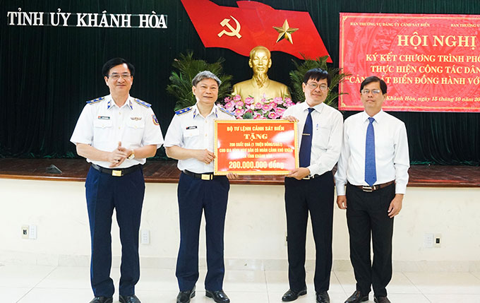 Trung tướng Hoàng Văn Đồng (bìa trái)  và Trung tướng Nguyễn Văn Sơn trao tượng trưng 200 suất quà cho gia đình ngư dân Khánh Hòa. 
