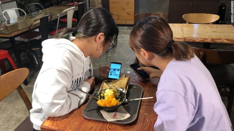 Yoo Chae-rin (bên trái) sử dụng điện thoại thông minh để giải trí và trò chuyện cùng bạn bè. Ảnh: CNN