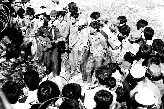 Nhạc sĩ Xuân An cùng ôm đàn hát với chiến sĩ đảo Trường Sa.  Ảnh: Phóng viên Viết Thái (Báo Phú Khánh) chụp tháng 4-1988.