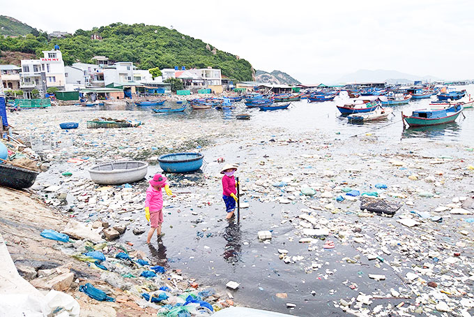 Người dân vớt rác ở bờ biển Bình Ba.