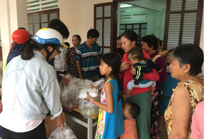 Offering food to people at shelter in Vinh Truong Ward