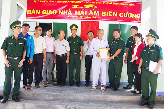Đại tá Nguyễn Ngãi Hài - Phó Chính ủy Bộ đội Biên phòng tỉnh  trao quyết định cho gia đình bà Tẩu và ông Mông.