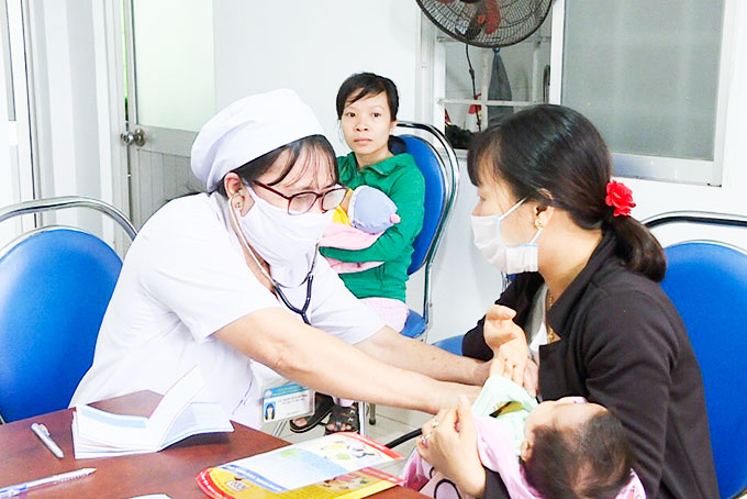 Cán bộ Trung tâm Y tế huyện Diên Khánh  lấy máu khám sàng lọc sơ sinh cho trẻ.
