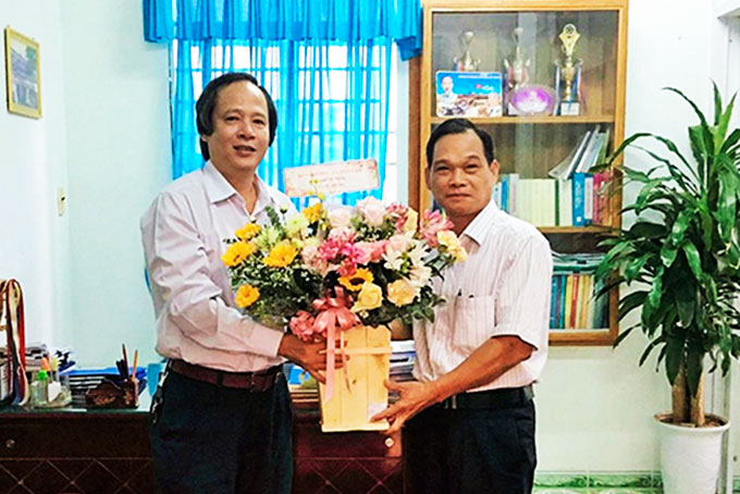 Ông Đỗ Hữu Quỳnh - Phó Giám đốc Sở Giáo dục và Đào tạo tặng hoa cho Phòng Giáo dục và Đào tạo huyện Khánh Vĩnh.