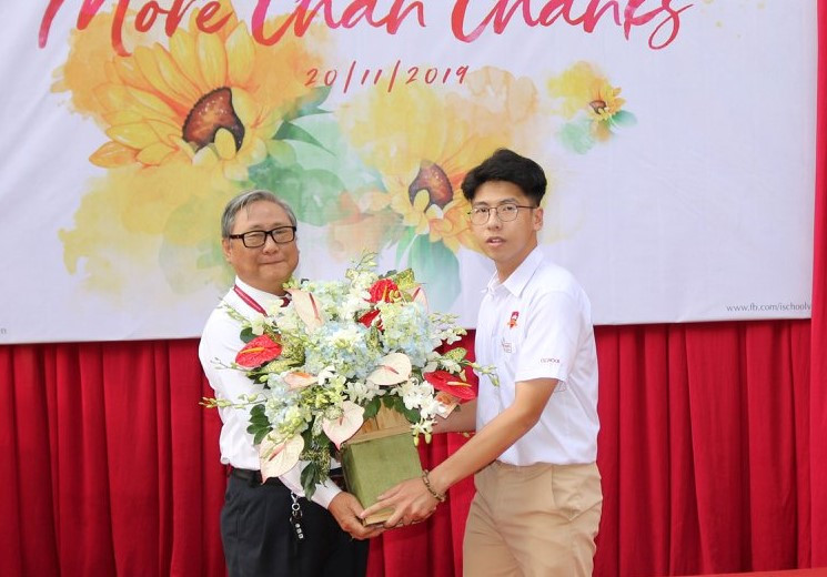 Đại diện học sinh tặng hoa cho thầy Phạm Hữu Bình - Hiệu trưởng nhà trường. 
