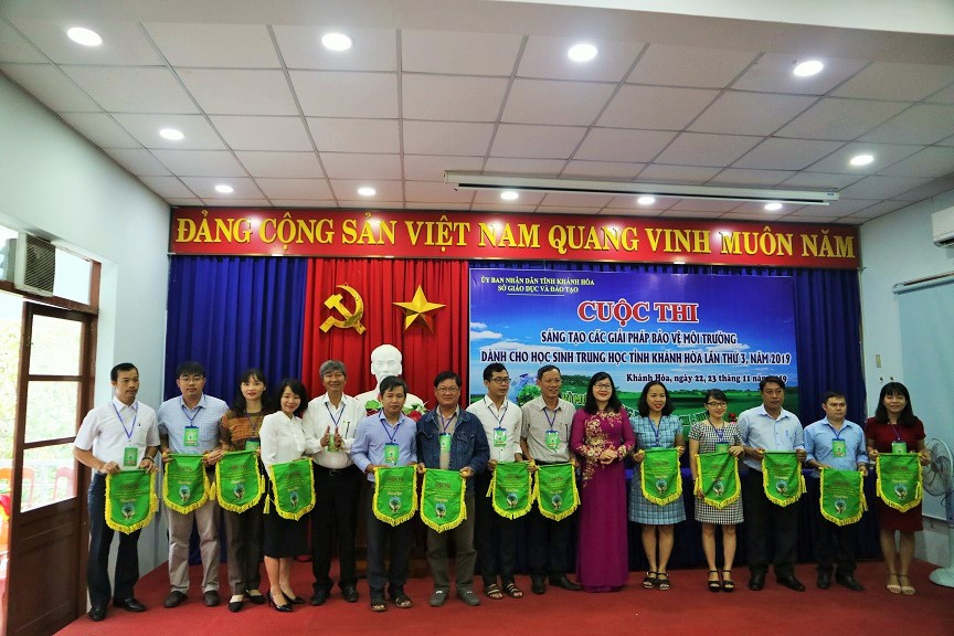 Hoang Thi Ly, deputy director in charge of Khanh Hoa’s Department of Education and Training, offering souvenir flags to participating teams