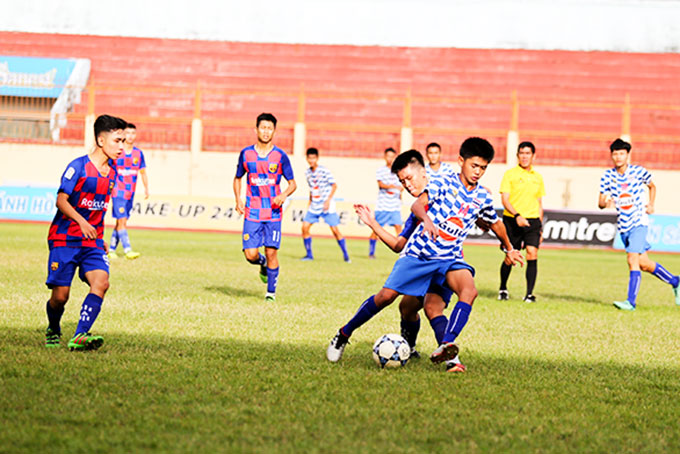 Cầu thủ U15 Thái Lan (trước) trong một pha tranh bóng với cầu thủ U15 Diên Khánh.