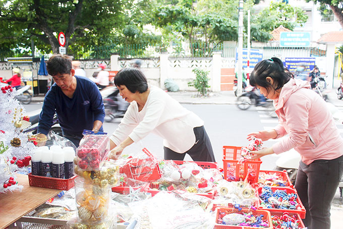 Người dân mua đồ trang trí Giáng sinh  tại một cửa hàng trên đường Nguyễn Trãi (TP. Nha Trang).