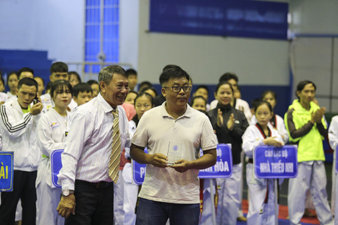 Ban tổ chức tặng kỷ niệm chương tri ân cho người nhà gia đình cố võ sư Trần Đình Cải.