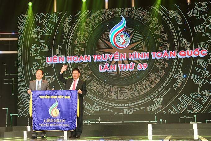 Leader of of Khanh Hoa Radio and Television Station (right) handing over flag to leader of Ninh Binh Province’s Radio and Television Station