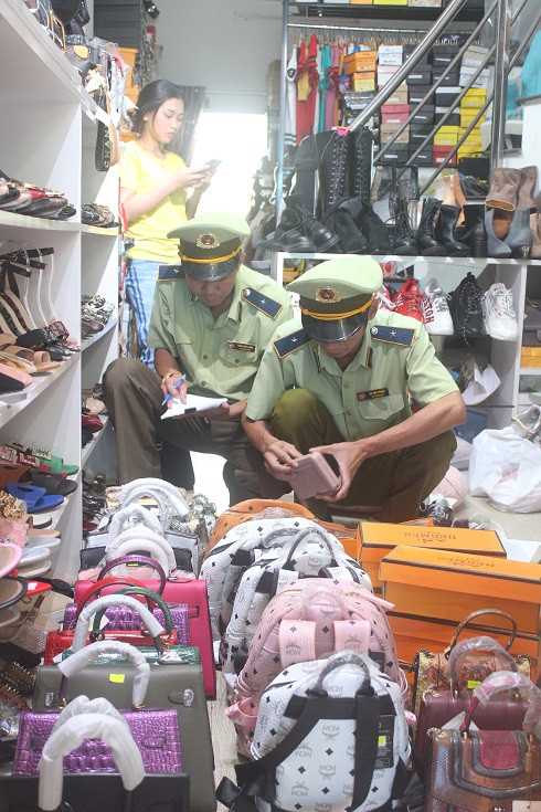 Đội Quản lý thị trường số 1 kiểm đếm túi xách, giày dép thu giữ tại cửa hàng 96 Quang Trung.