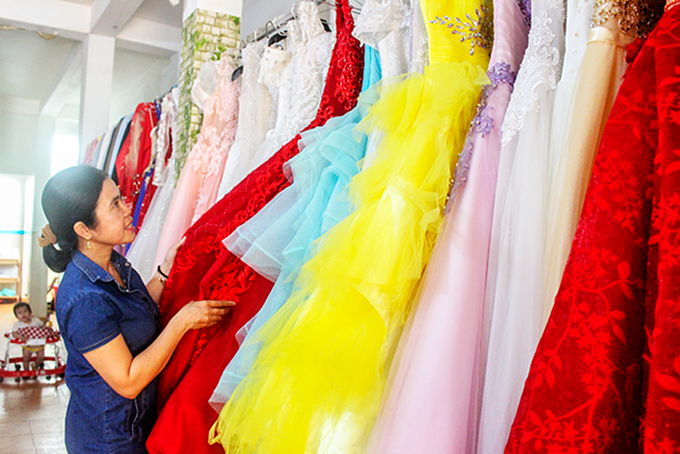 Bà Đặng Thị Bích Trâm sắp xếp lại váy cưới của tiệm áo cưới “0 đồng”.